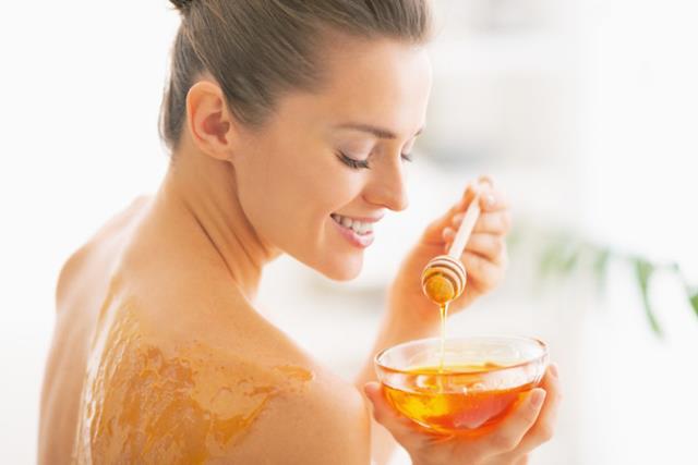 Happy young woman enjoying honey spa therapy